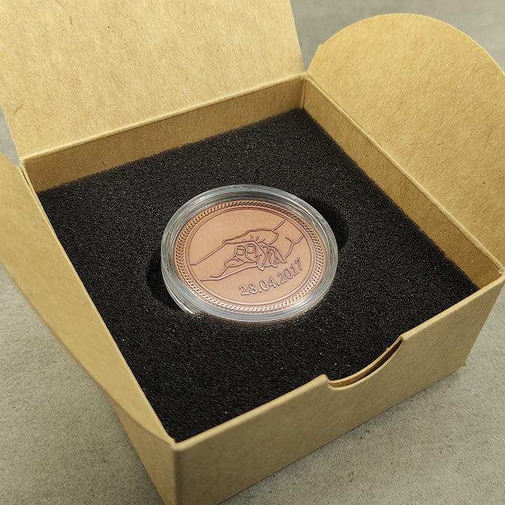 Custom copper coin for couples in a protective acrylic capsule and premium gift box with black foam insert, showcasing metal texture.
