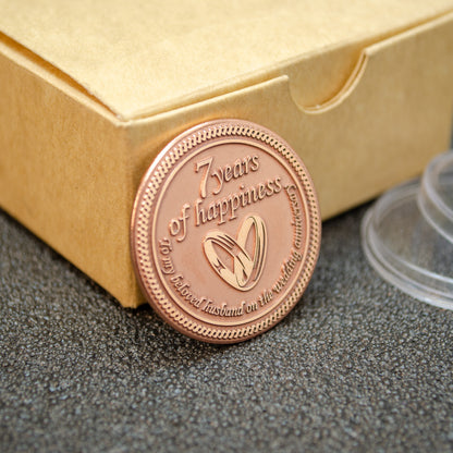 Hand-polished copper anniversary coin leaning on a craft gift box, personalized wedding anniversary token with deep engraving.