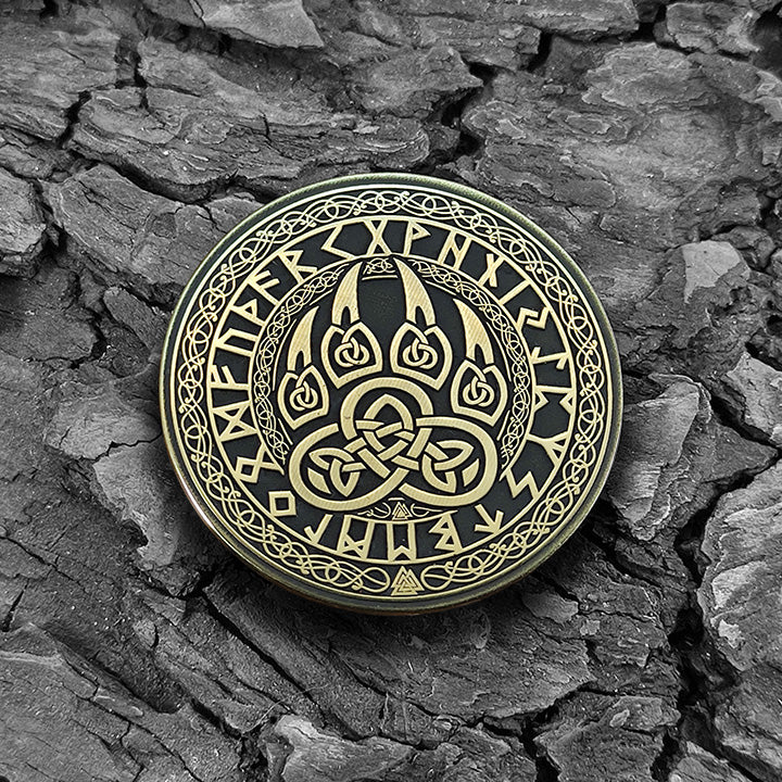Viking brass coin Bear Paw on a natural dark texture background highlighting antique finish.