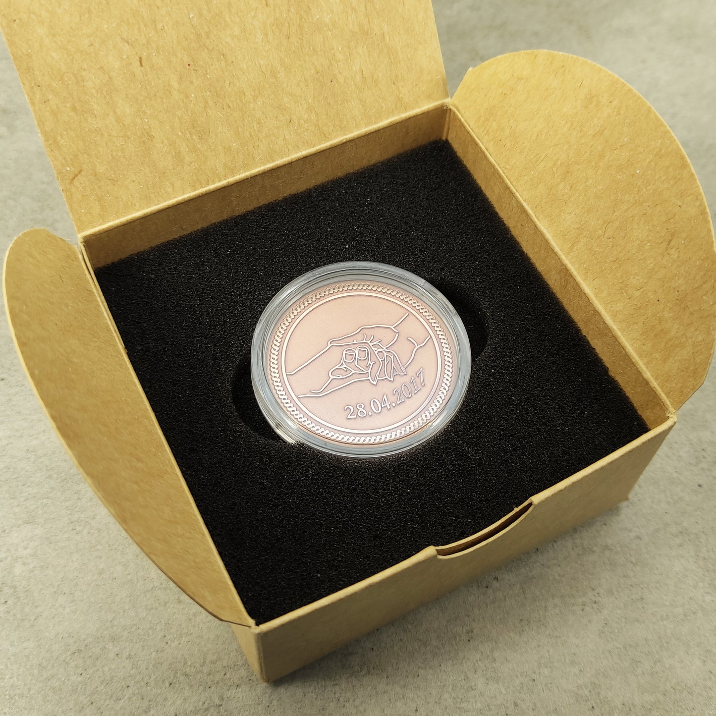Top view of the personalized copper gift coin in a square craft box, highlighting the polished copper surface and engraved anniversary date.