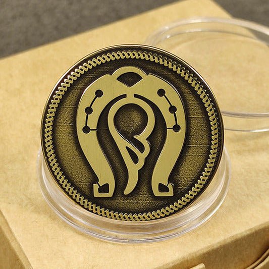 Close-up of a brass horseshoe of prosperity coin with angel wing engraving and vintage dark patina in a clear capsule.