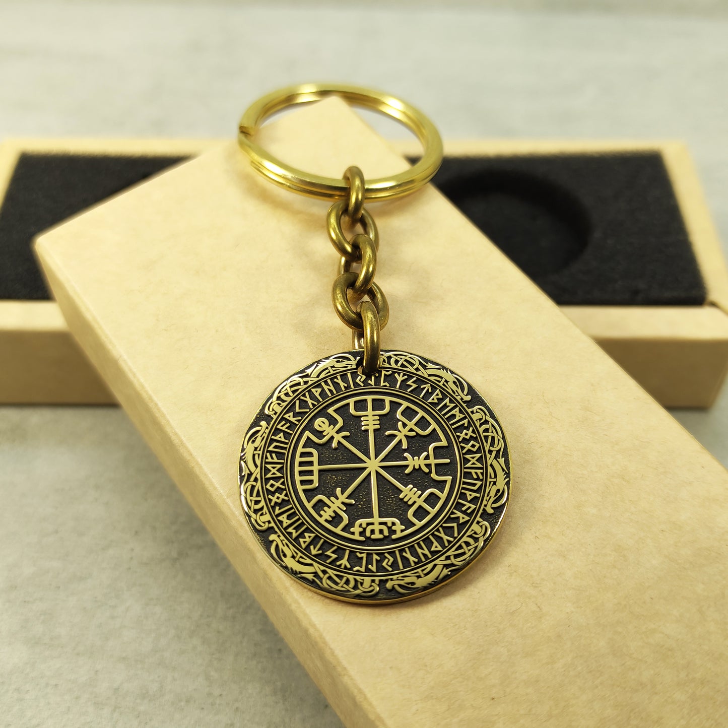 Handcrafted brass Vegvisir medal keychain presented on a rustic gift box, showcasing the 32mm diameter and professional deep laser etching.