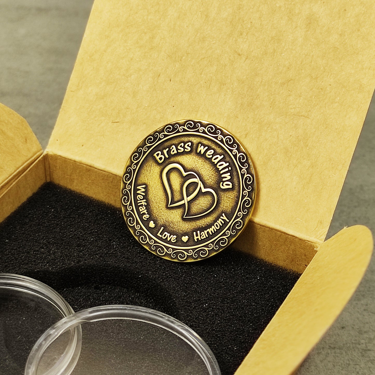 Custom brass wedding gift coin placed in a premium kraft paper gift box with black foam insert for 21st anniversary celebration.