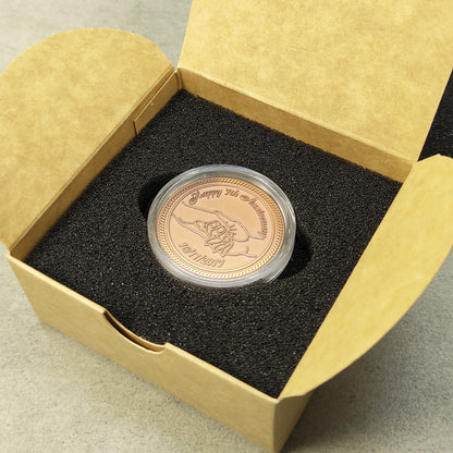 Top view of a personalized copper anniversary coin in a gift box, custom wedding date engraving, elegant commemorative gift in capsule.