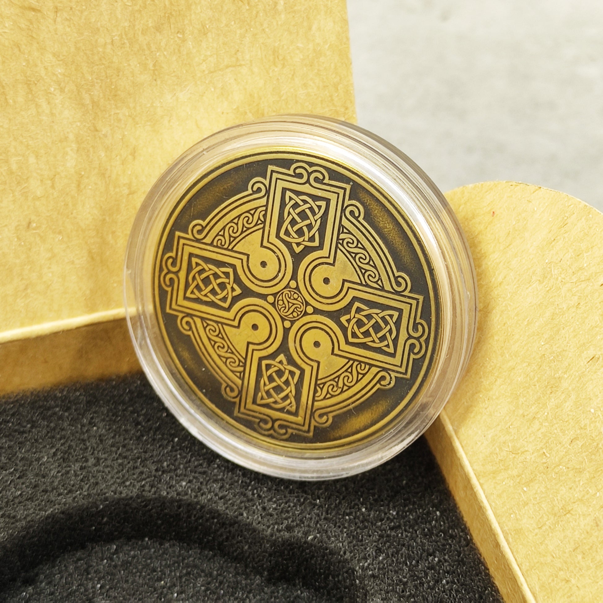 Custom engraved Celtic brass amulet in a protective acrylic capsule and craft gift box, unique spiritual gift presentation.