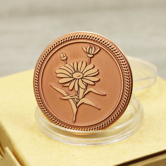 Close-up of a pure copper Daisy coin featuring deep laser engraving, matte finish, and decorative rope border on a personalized gift box.