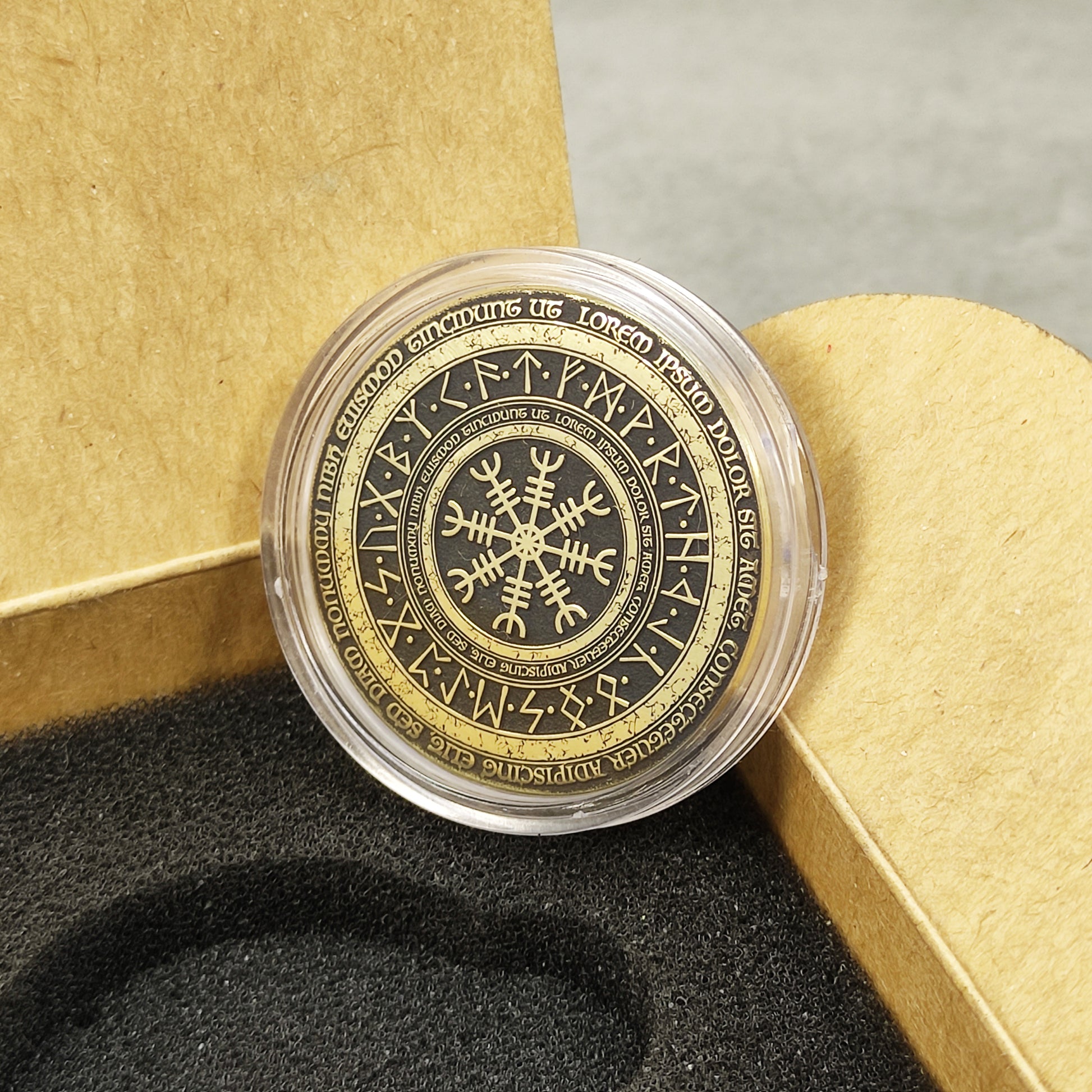 Engraved brass coin in a protective acrylic capsule, placed inside a premium gift box insert.