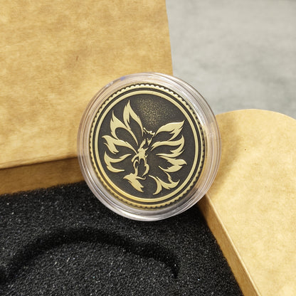 Close-up of personalized brass Kitsune coin protected in a transparent plastic capsule, ready for gift giving.