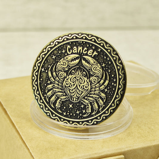 Close-up of Cancer zodiac brass medal with deep laser engraving of a crab, features antique dark patina finish and decorative celestial border in a protective capsule.