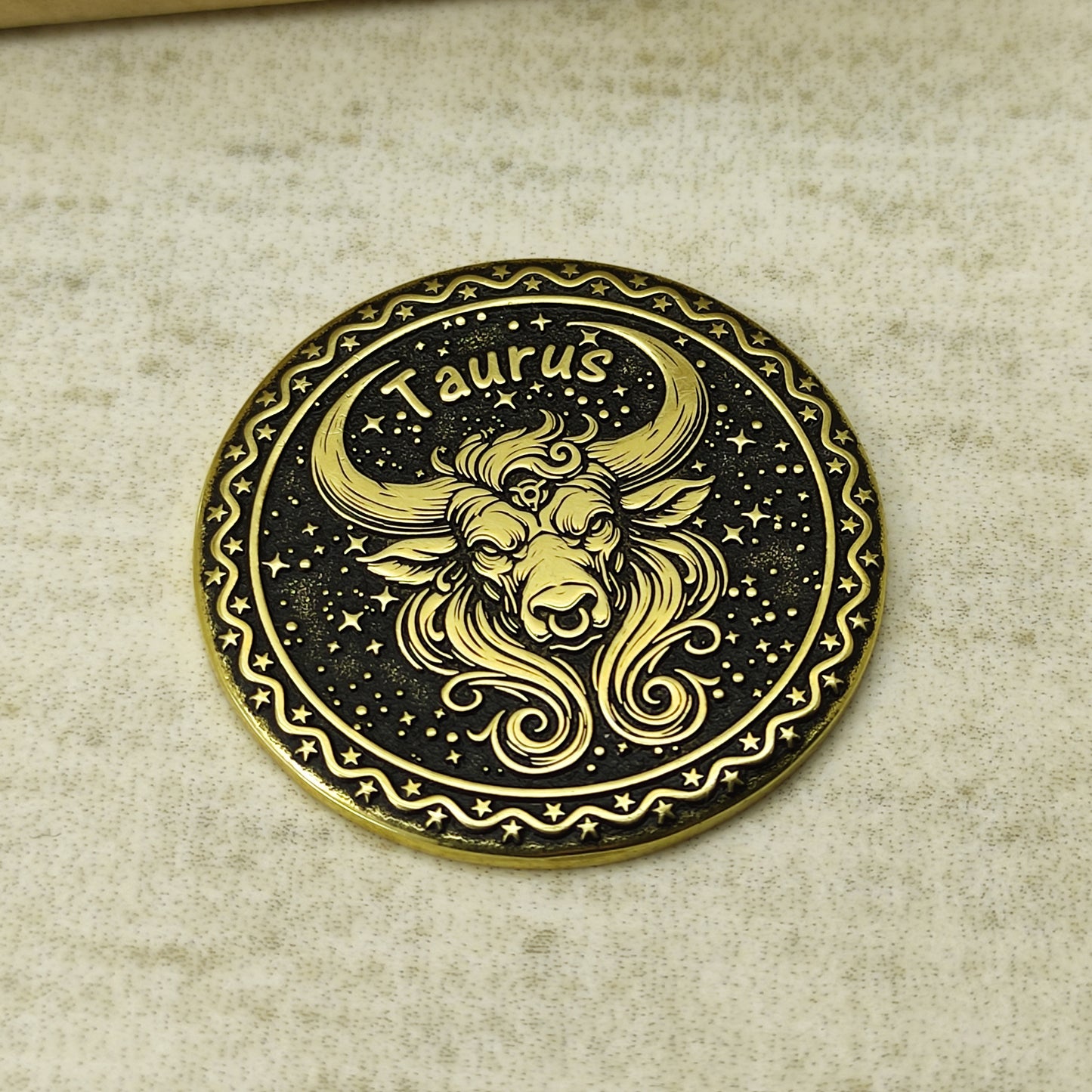 Detailed view of the Taurus zodiac brass medal, highlighting the intricate 3D-style engraving and dark recessed patina on the polished brass surface.