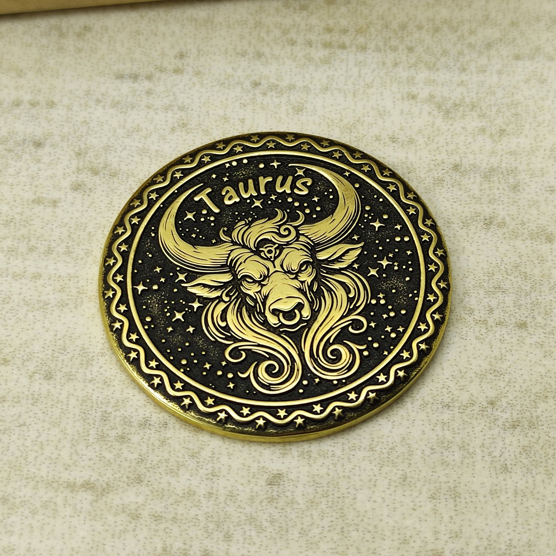 Detailed view of the Taurus zodiac brass medal, highlighting the intricate 3D-style engraving and dark recessed patina on the polished brass surface.