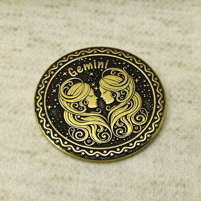 Detailed view of the Gemini zodiac brass medal, highlighting the intricate 3D-style engraving and dark recessed patina on the polished brass surface.