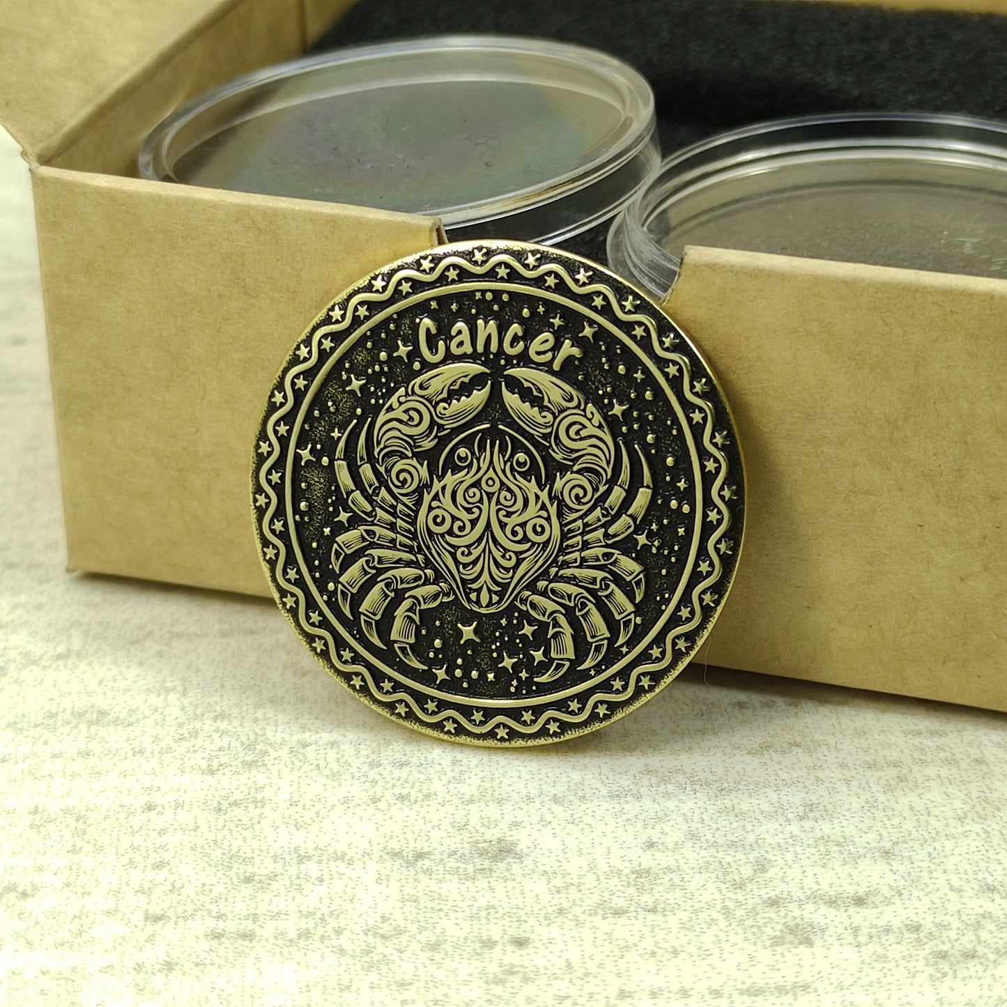 Cancer zodiac brass medal presented with minimalist gift packaging, showcasing the 32mm diameter and premium metal quality of the custom engraved coin.