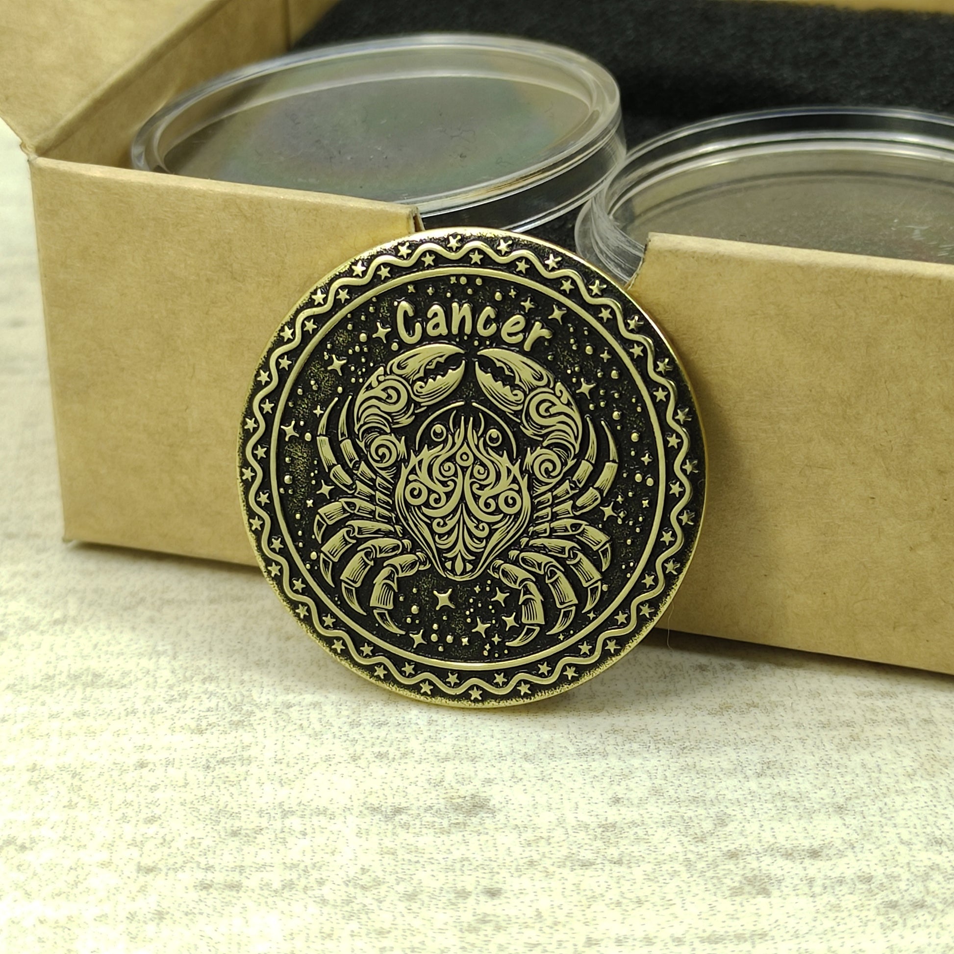 Cancer zodiac brass medal presented with minimalist gift packaging, showcasing the 32mm diameter and premium metal quality of the custom engraved coin.