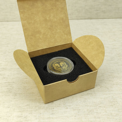 Gemini zodiac brass medal in a small square craft gift box, professional presentation of a personalized astrology souvenir with dark patina finish.