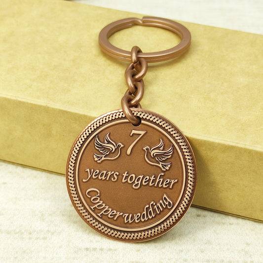 7th wedding anniversary copper coin keychain with "7 years together" deep engraving and antique patina.