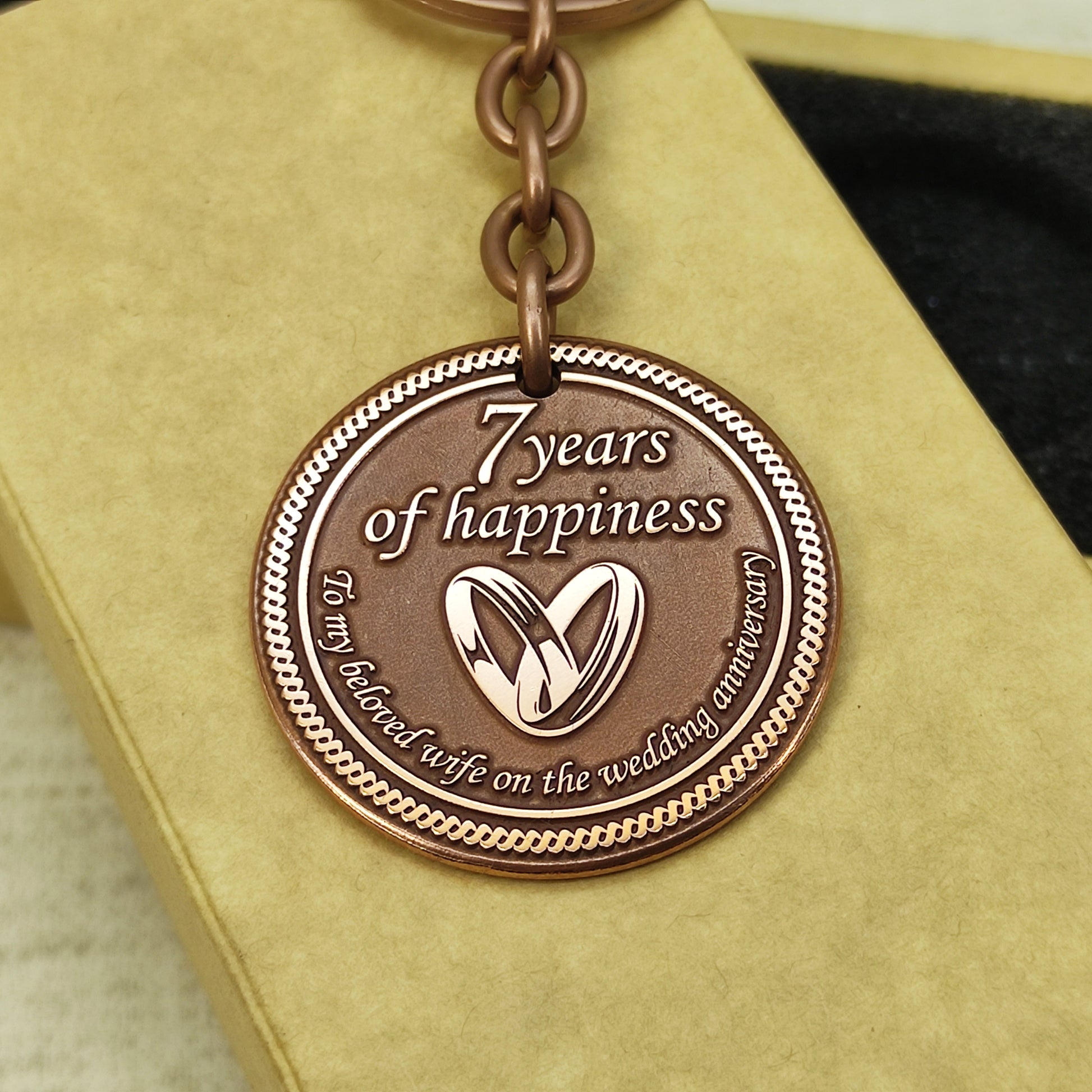 Engraved copper keychain coin for 7 years of marriage celebration, personalized gift with sturdy metal ring and antique finish.