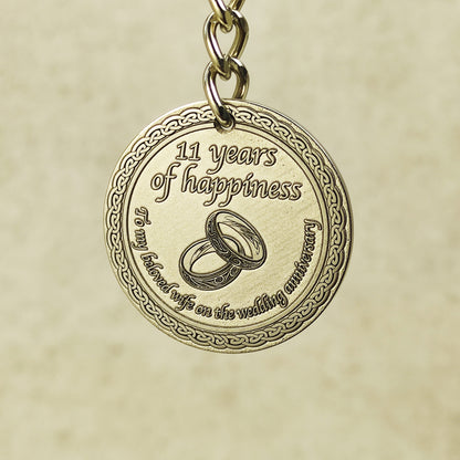 Detailed macro shot of engraved brass anniversary coin, showcasing high-precision laser etching and decorative celtic border on a 32mm metal keychain.