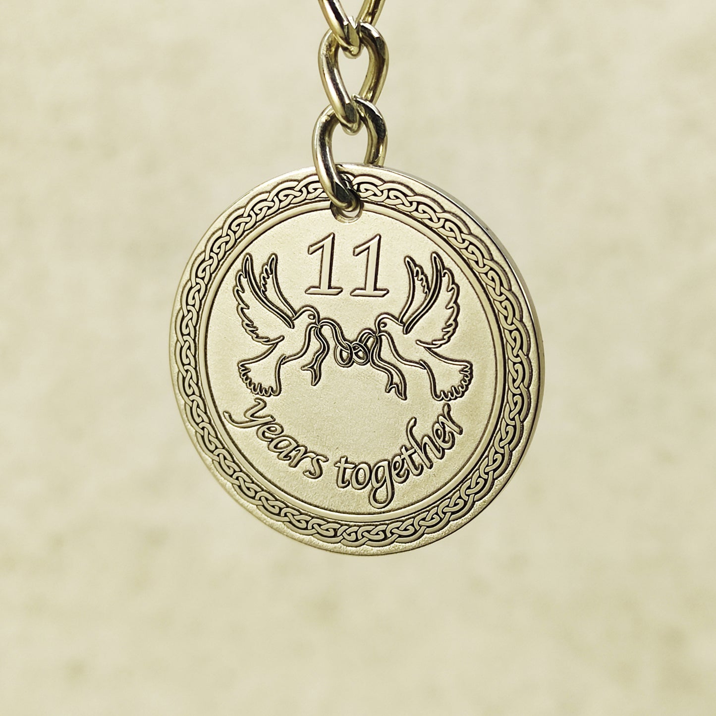 Close-up of handcrafted stainless steel coin pendant for 11th anniversary featuring "11 years together" text.