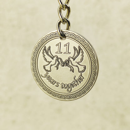 Close-up of handcrafted stainless steel coin pendant for 11th anniversary featuring "11 years together" text.