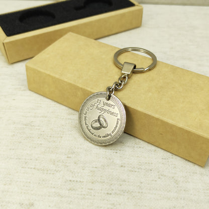 Brass anniversary keychain with steel ring and chain attachment, showcasing the solid metal construction and professional patina treatment on the engraved surface.