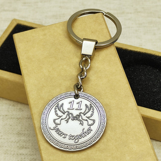 Personalized stainless steel coin keychain for 11th wedding anniversary with deep laser engraved doves.