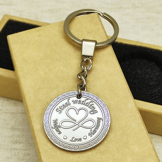 Personalized stainless steel coin keychain for 11th wedding anniversary with deep engraved infinity heart symbol.