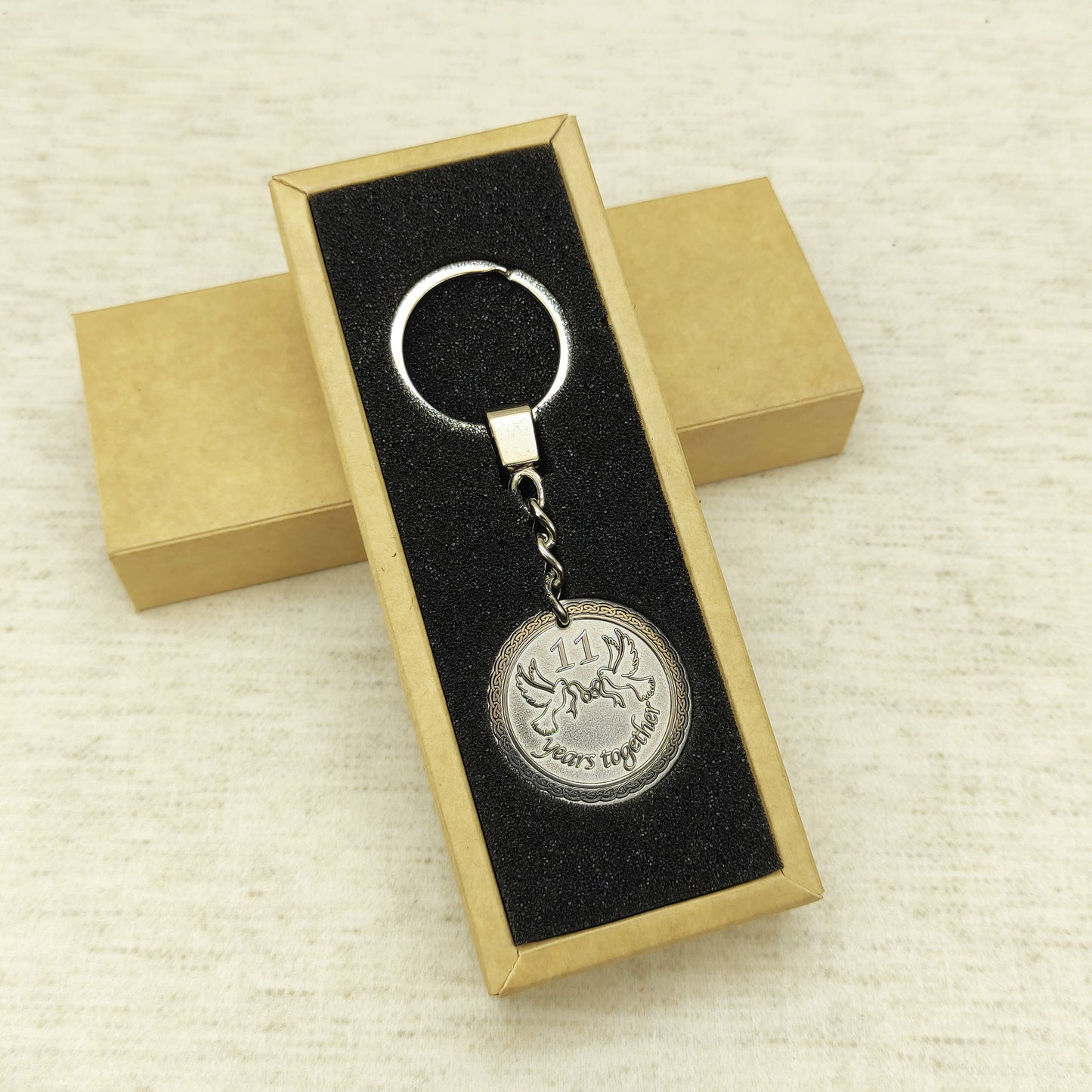 Customized stainless steel anniversary keychain presented in an elegant black foam insert gift box.