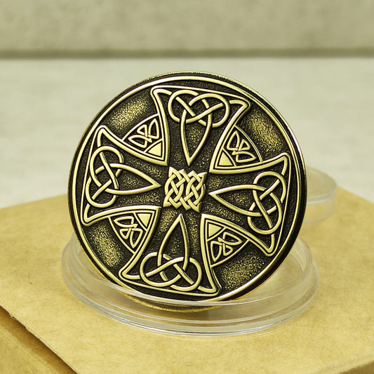 Handcrafted brass Celtic cross coin, 32mm diameter, intricate knotwork engraving with black patina finish.