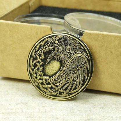 Perspective view of a 2mm thick brass challenge coin in a gift box, showcasing the metallic luster and intricate Viking bird design.