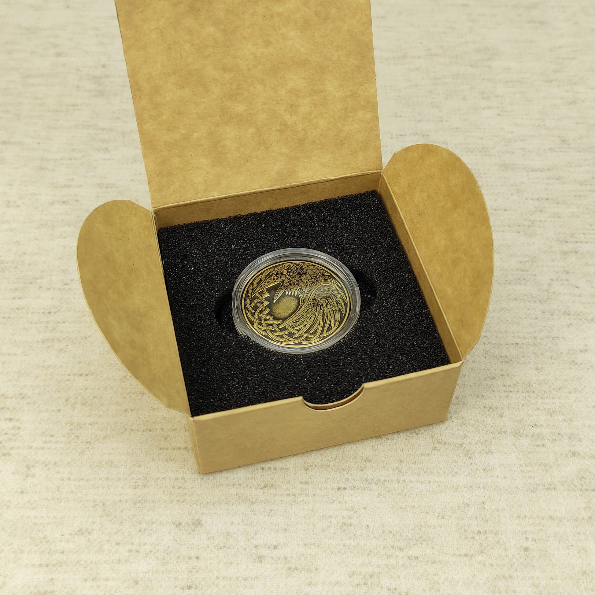 Personalized brass Raven coin in a protective capsule and craft gift box, premium presentation of a Norse mythology gift.