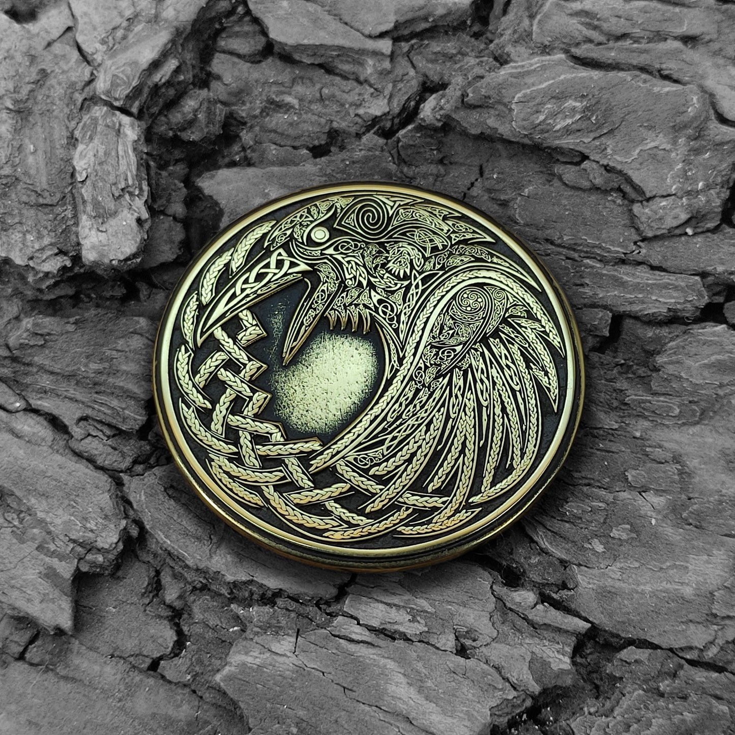 Handmade Viking Raven brass coin on a natural bark background, showcasing the aged patina and ancient Nordic aesthetic.