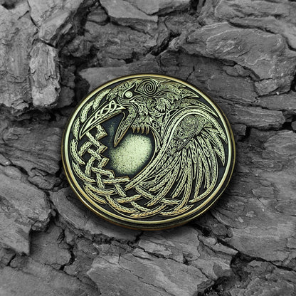 Handmade Viking Raven brass coin on a natural bark background, showcasing the aged patina and ancient Nordic aesthetic.