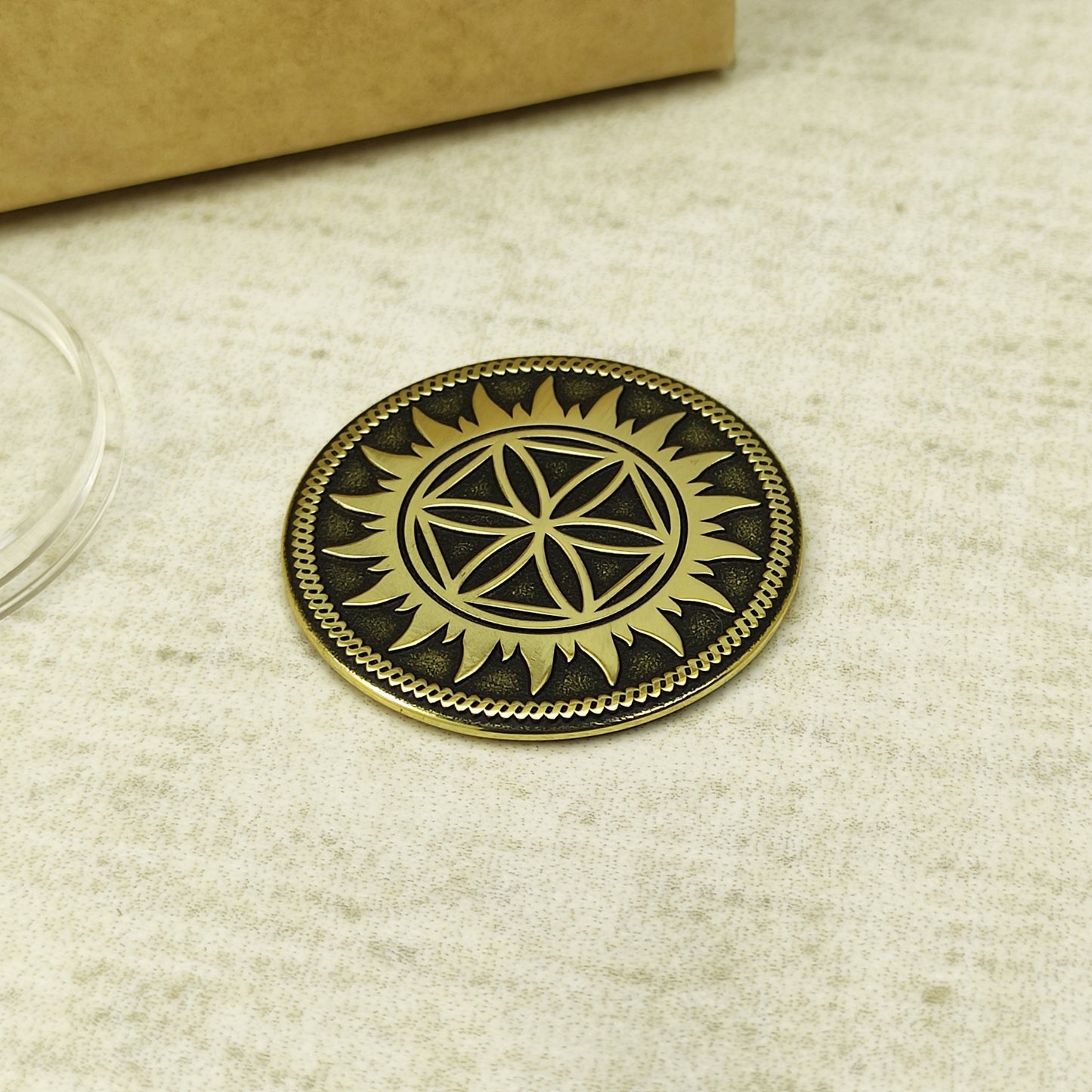 Custom engraved brass coin featuring Slavic Perun Star symbol with blackened background texture on linen surface.
