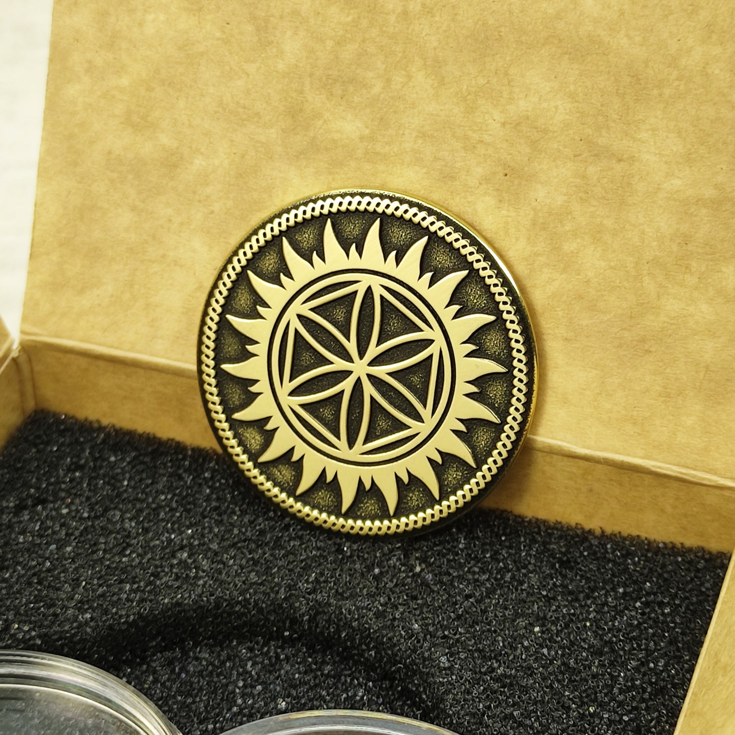 Personalized brass Slavic coin with Perun Star emblem inside a premium kraft paper gift box with black foam insert.