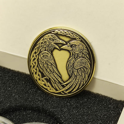 Perspective view of a personalized Huginn and Muninn brass token in a premium gift box, high-quality laser etched metal gift.
