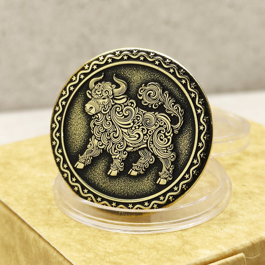 Close-up of a brass Chinese zodiac coin Year of the Ox, featuring deep laser engraving, antique patina finish, and decorative star border on a gift box.