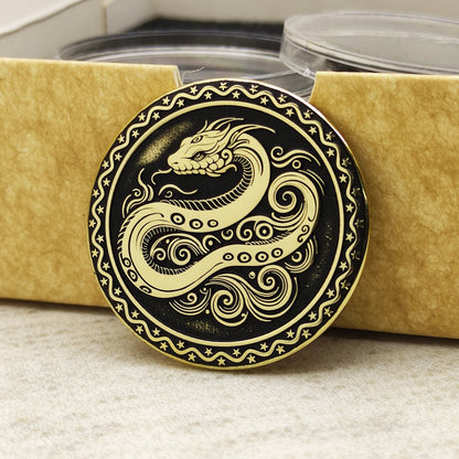 Brass Year of the Snake zodiac coin leaning against an eco-friendly craft gift box, highlighting the polished brass quality and ornamental edge.