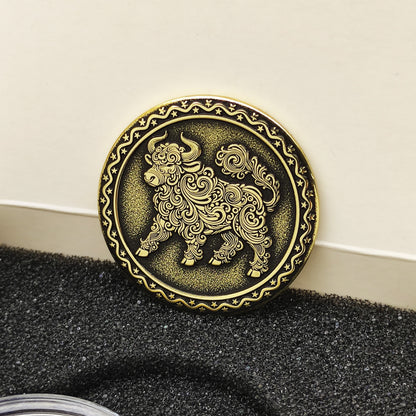 Vertical view of the personalized brass zodiac medal in a premium black insert box, showcasing the antique finish and engraved ornamental border.