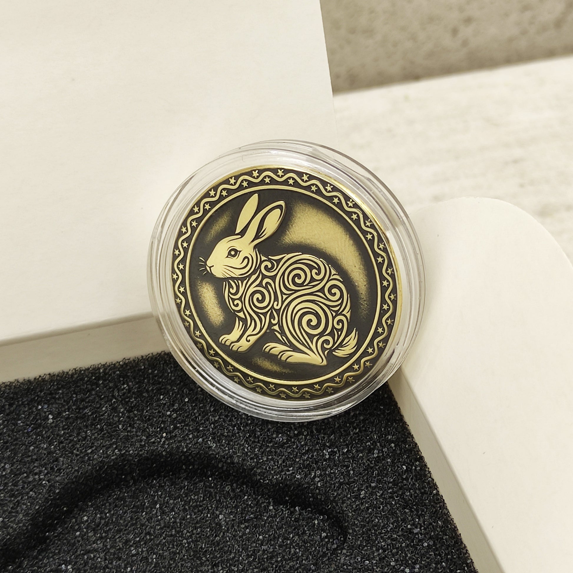 Macro photo of the brass Rabbit coin in a protective capsule, highlighting the intricate dark recessed patina engraving for high contrast.