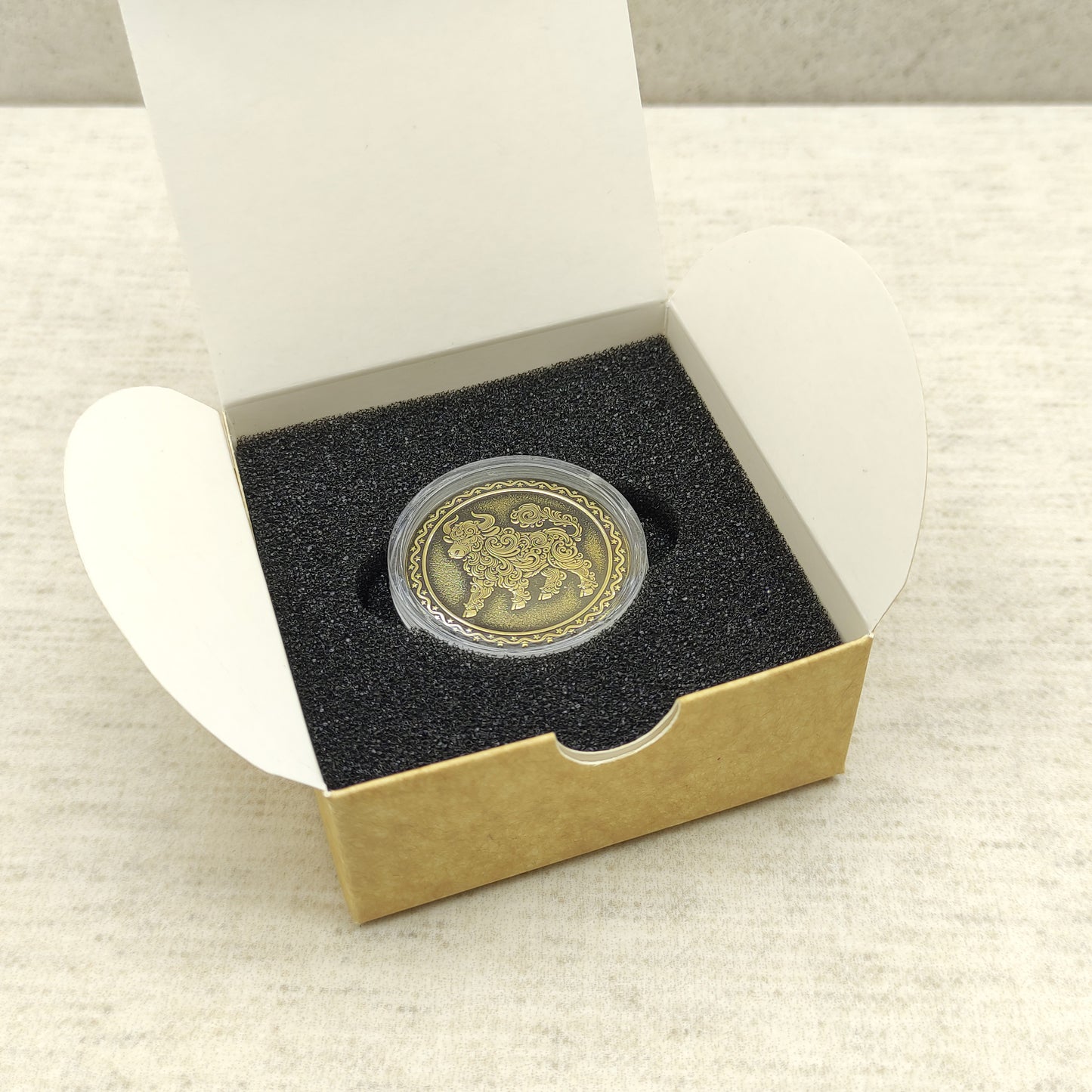 Ready-to-gift personalized brass zodiac medal, handmade Chinese Year of the Ox coin in a square craft box with black foam insert.