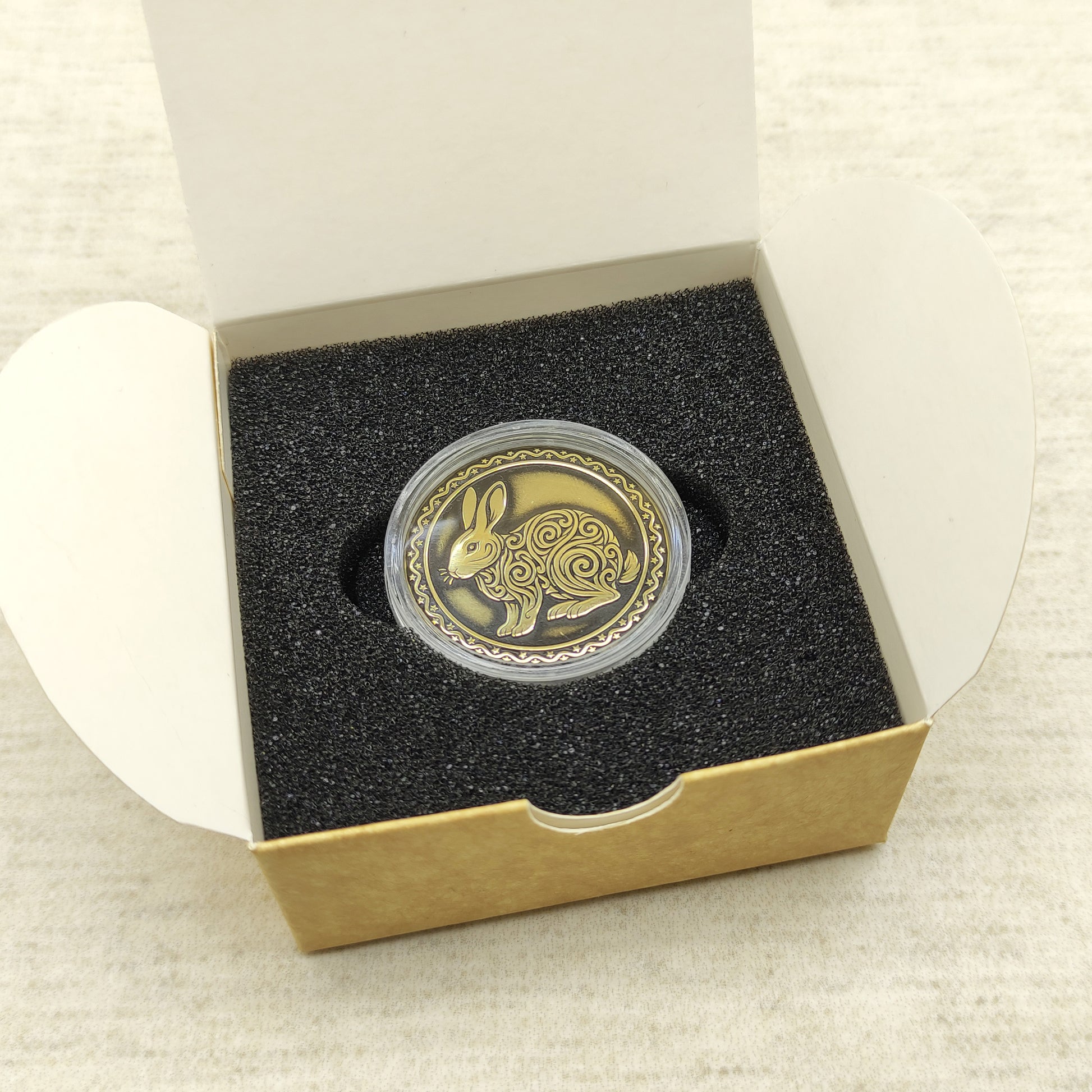 Ready-to-gift personalized brass zodiac medal, handmade Chinese Year of the Rabbit coin in a square craft box with black foam insert.