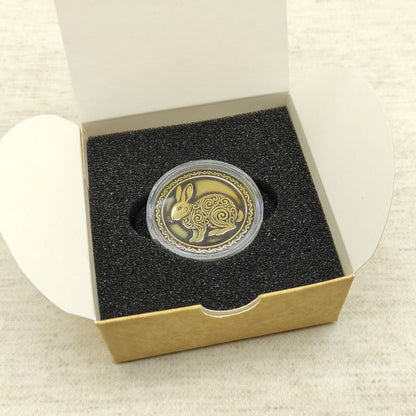 Ready-to-gift personalized brass zodiac medal, handmade Chinese Year of the Rabbit coin in a square craft box with black foam insert.