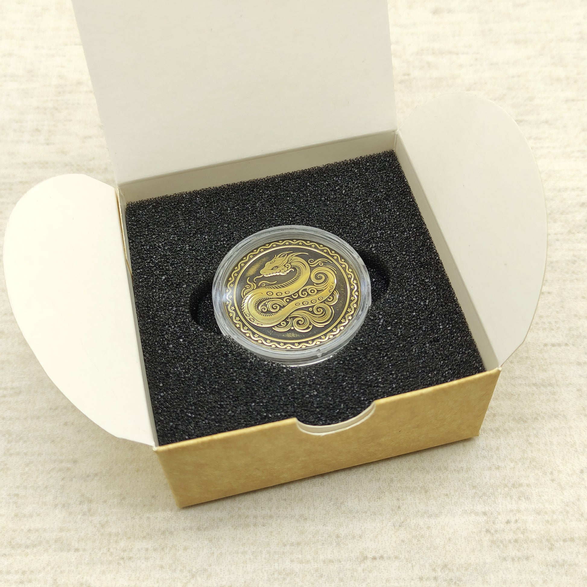 Ready-to-gift personalized brass zodiac medal, handmade Chinese Year of the Snake coin in a square craft box with black foam insert.