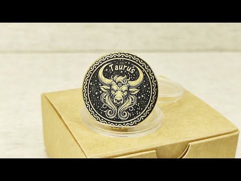 Personalized brass Taurus zodiac coin placed on a craft gift box, showcasing the durable metal texture and high-contrast professional patina treatment.