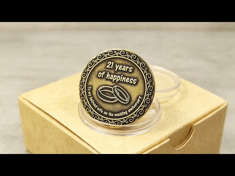 Product video of custom engraved brass anniversary coin for 21 years of marriage in a premium kraft paper gift box.