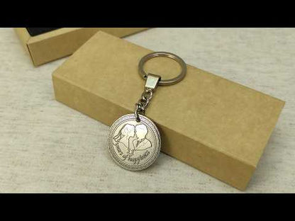 Stainless steel anniversary coin keychain placed on a craft gift box, durable metal personalized gift for 11th steel wedding anniversary celebration.